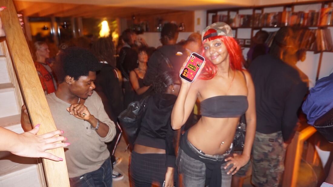 Guest in a red wig dancing with the Giddy screen