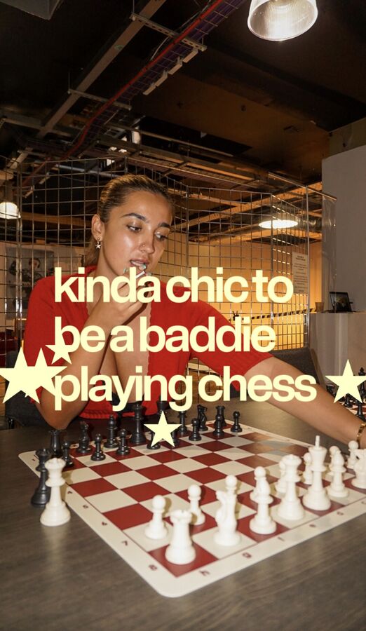 Woman in red playing chess with the caption kinda chic to be a baddie playing chess
